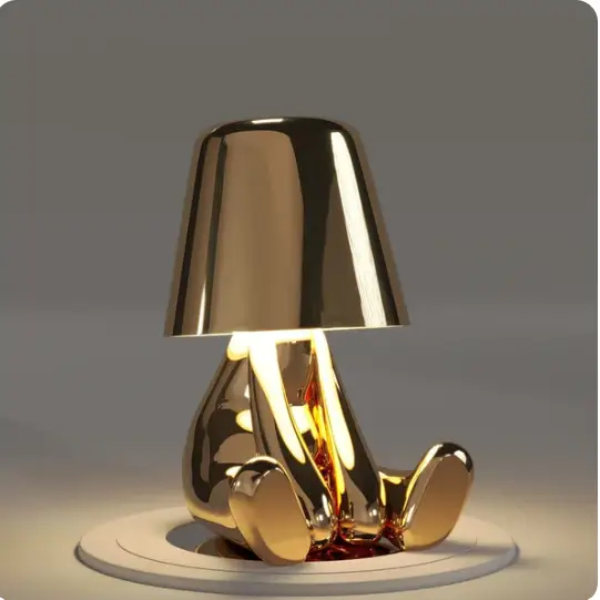 Lampe LED sans fil en or, design sculptural, lumière douce, parfaite pour créer une ambiance chaleureuse et moderne.