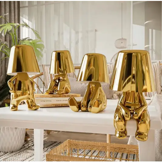 Lampe LED sans fil en or, design sculptural, lumière douce, parfaite pour créer une ambiance chaleureuse et moderne.