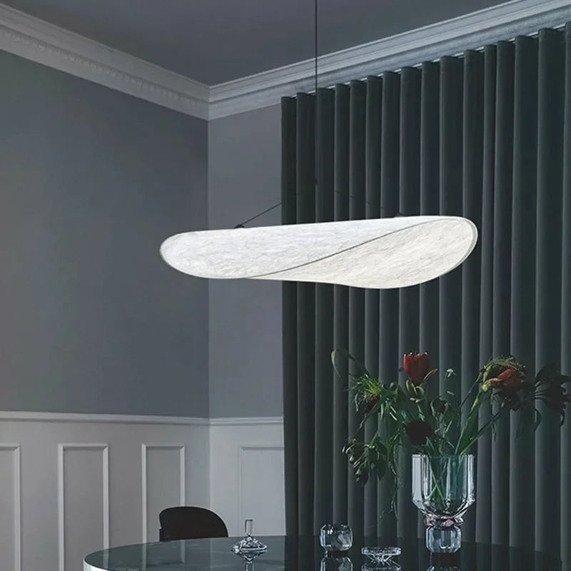 Lampe suspendue design en soie, formes fluides et élégantes, créant une lumière douce pour un intérieur chic et apaisant.