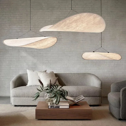 Lampe suspendue design en soie, formes fluides et élégantes, créant une lumière douce pour un intérieur chic et apaisant.