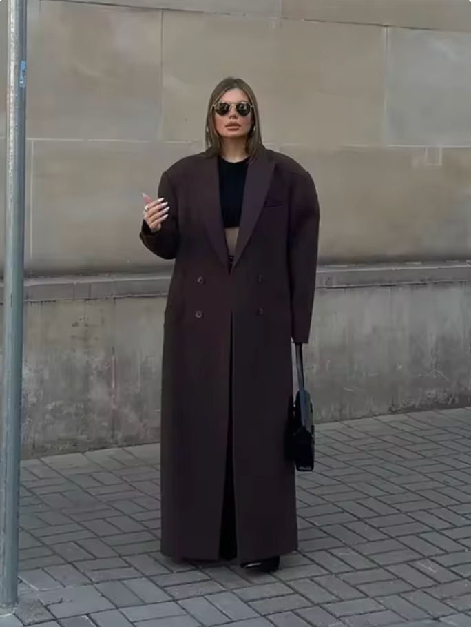 "Manteau long classique femme hiver élégant avec col imposant, coupe ajustée, couleur neutre, idéal saisons froides."