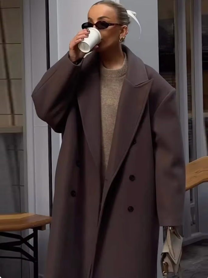 "Manteau long classique femme hiver élégant avec col imposant, coupe ajustée, couleur neutre, idéal saisons froides."