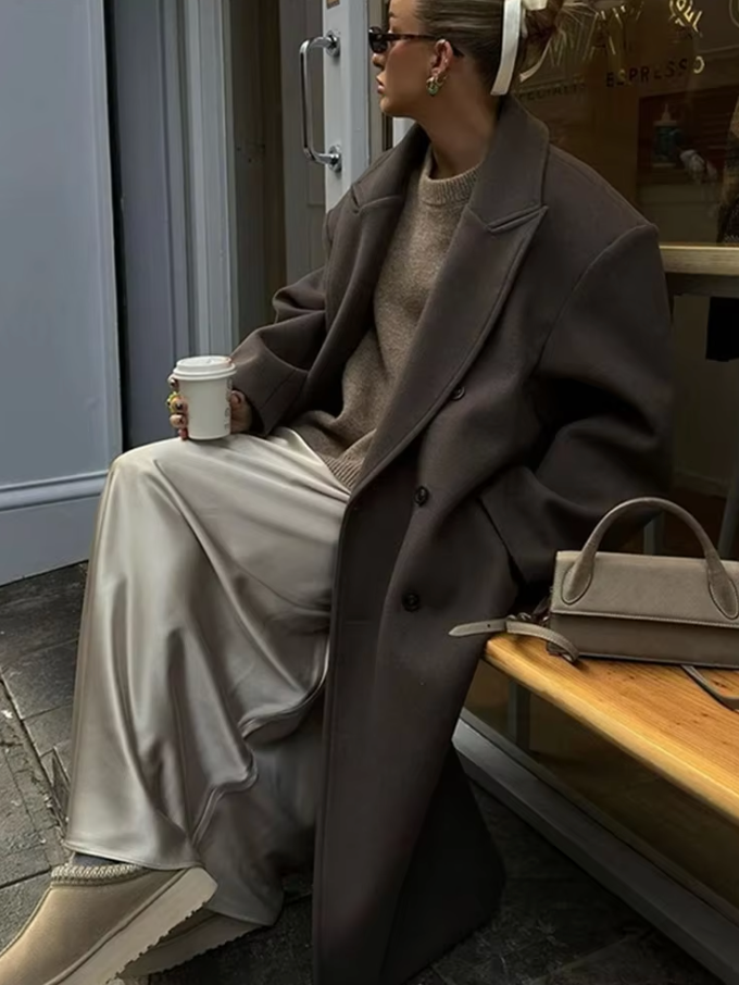 "Manteau long classique femme hiver élégant avec col imposant, coupe ajustée, couleur neutre, idéal saisons froides."