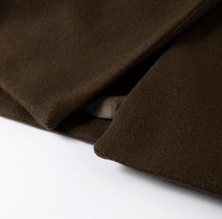 "Manteau long classique femme hiver élégant avec col imposant, coupe ajustée, couleur neutre, idéal saisons froides."