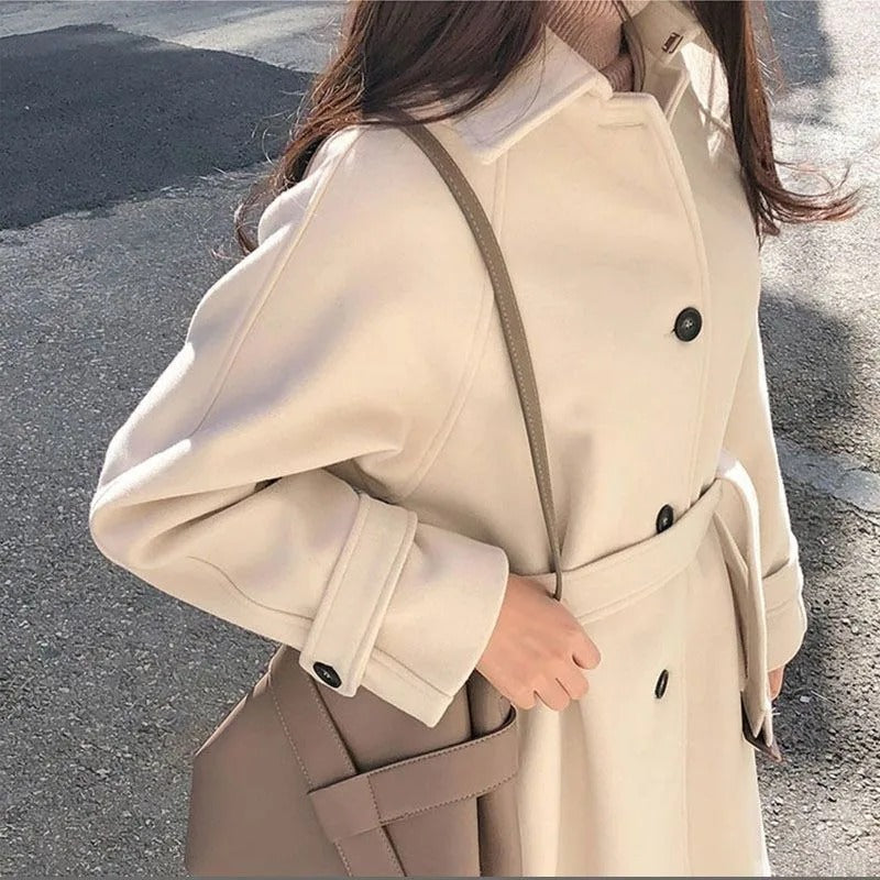 Manteau long femme élégant, silhouette ajustée, couleur sombre, idéal pour hiver, allie style et chaleur, look intemporel.