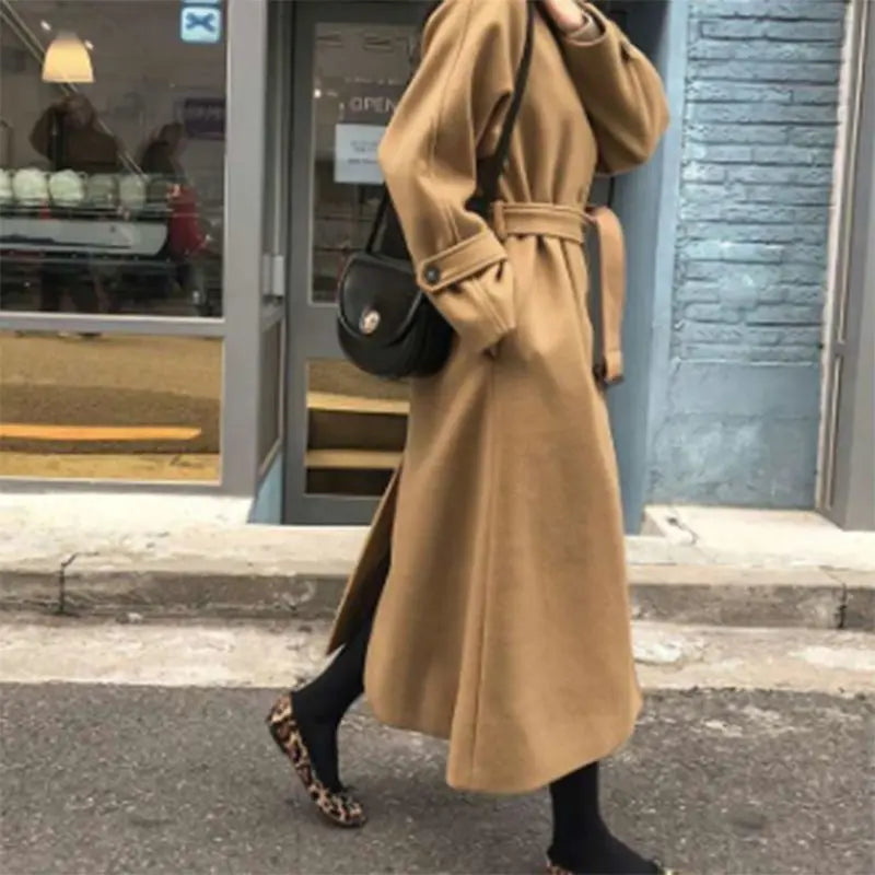 Manteau long femme élégant, silhouette ajustée, couleur sombre, idéal pour hiver, allie style et chaleur, look intemporel.