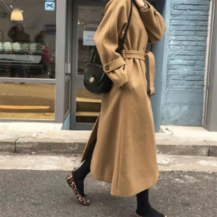 Manteau long femme élégant, silhouette ajustée, couleur sombre, idéal pour hiver, allie style et chaleur, look intemporel.