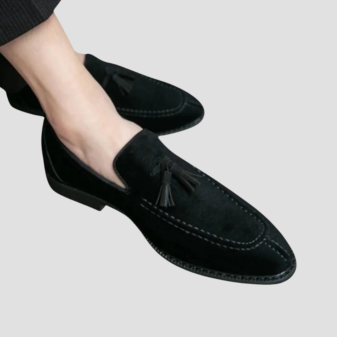 "Mocassins en daim pour homme, vue latérale, couleur marron avec pampilles élégantes, semelle caoutchouc, style raffiné."