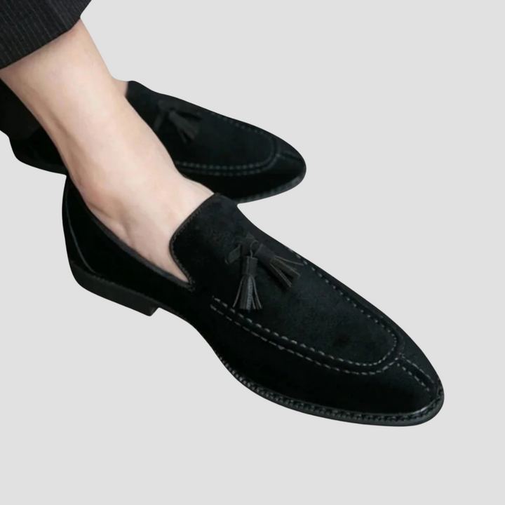 "Mocassins en daim pour homme, vue latérale, couleur marron avec pampilles élégantes, semelle caoutchouc, style raffiné."