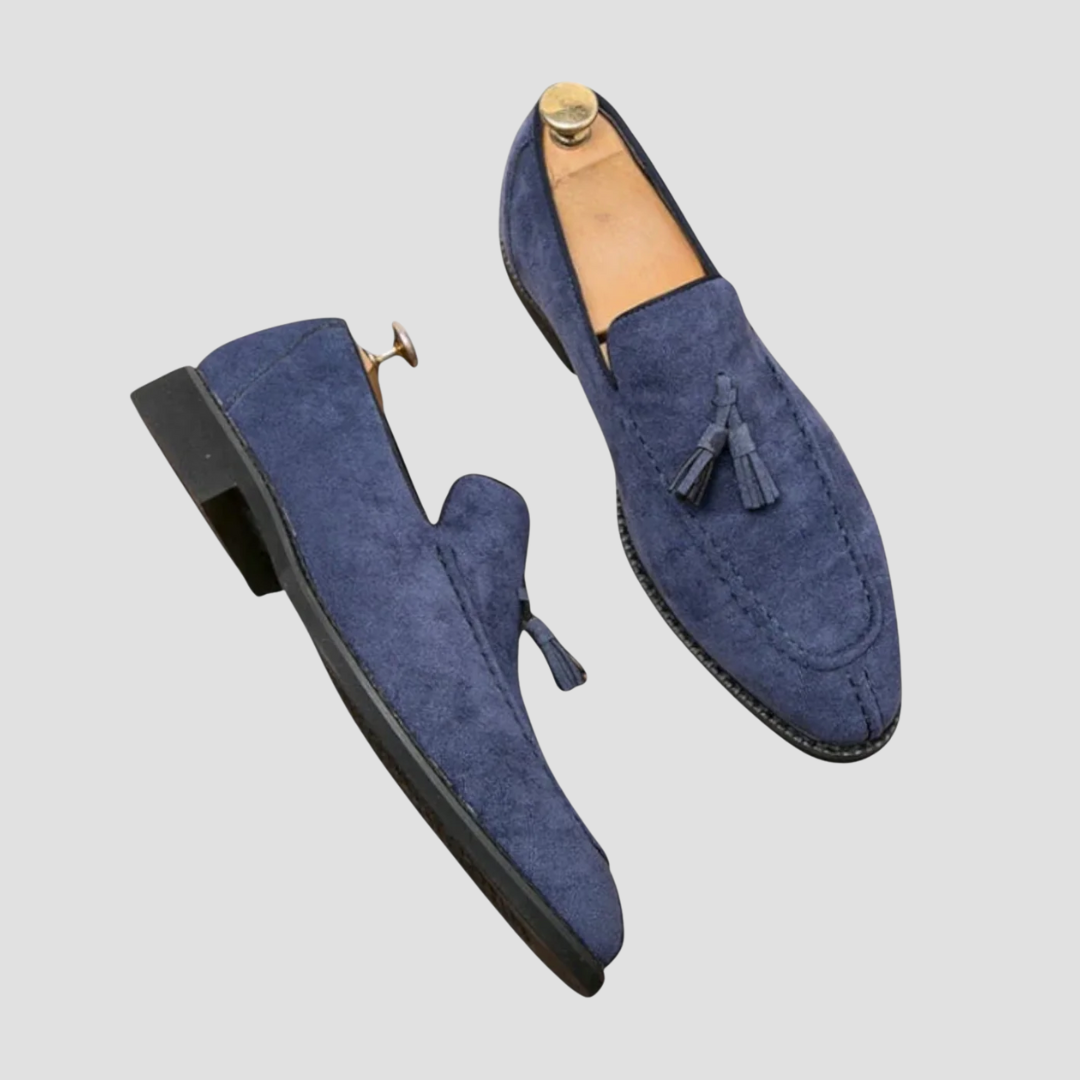 "Mocassins en daim pour homme, vue latérale, couleur marron avec pampilles élégantes, semelle caoutchouc, style raffiné."
