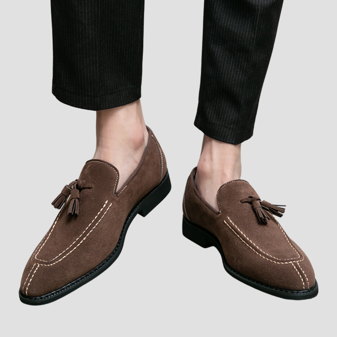 "Mocassins en daim pour homme, vue latérale, couleur marron avec pampilles élégantes, semelle caoutchouc, style raffiné."