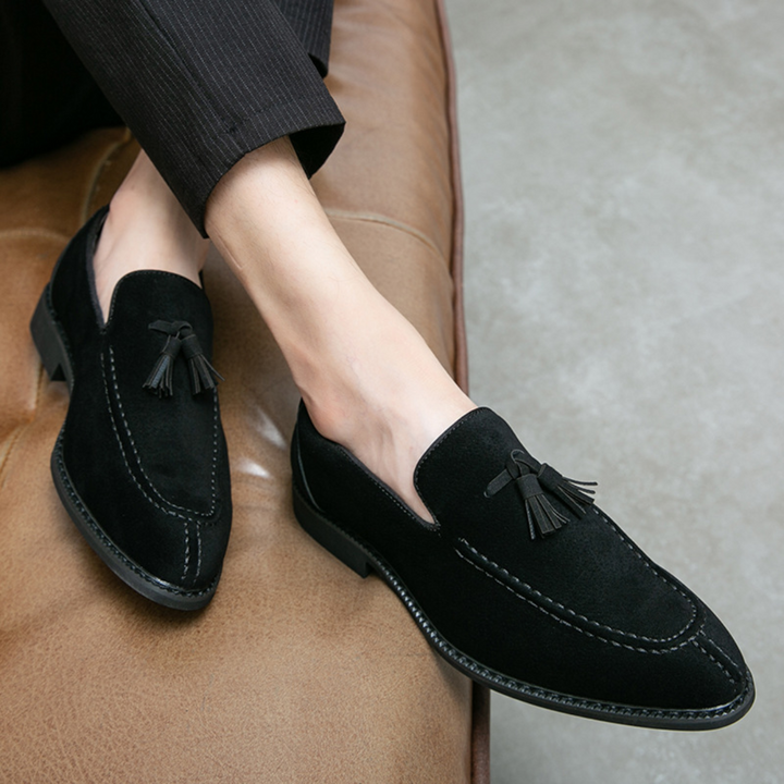 "Mocassins en daim pour homme, vue latérale, couleur marron avec pampilles élégantes, semelle caoutchouc, style raffiné."