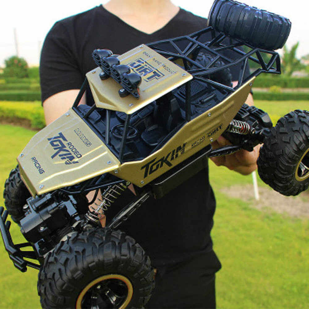"Monster Truck RC 4x4 rouge sur terrain rocailleux, suspension robuste et pneus antidérapants pour aventures extrêmes."