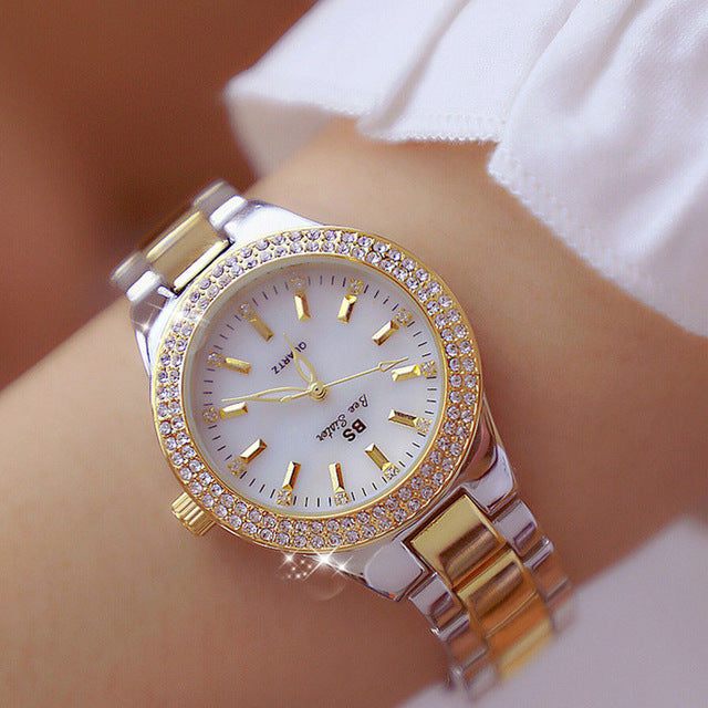 "Montre femme élégante avec strass scintillants et bracelet métallique argenté or doré, cadran rond lumineux."