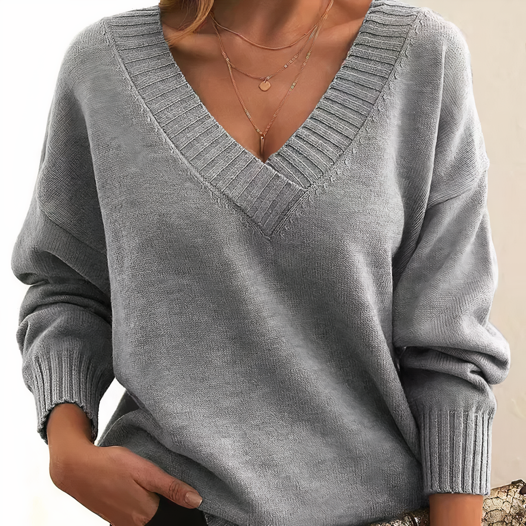 "Pull femme en cachemire col V, élégant et doux, fond beige, idéal pour élégance quotidienne et chaleur légère."