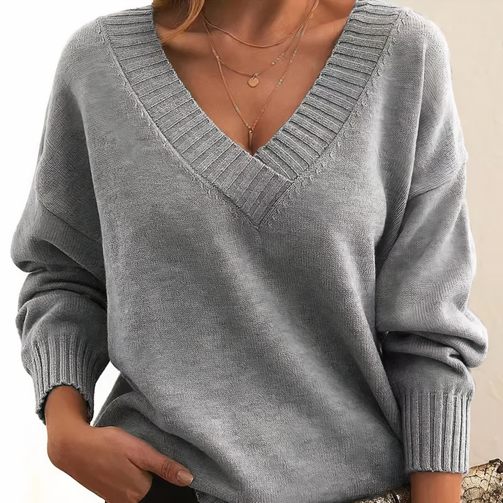 "Pull femme en cachemire col V, élégant et doux, fond beige, idéal pour élégance quotidienne et chaleur légère."