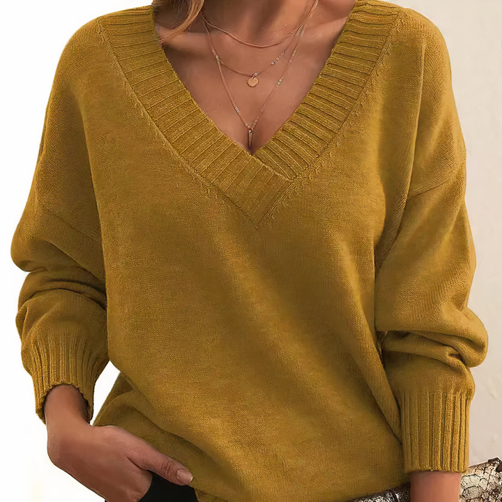 "Pull femme en cachemire col V, élégant et doux, fond beige, idéal pour élégance quotidienne et chaleur légère."
