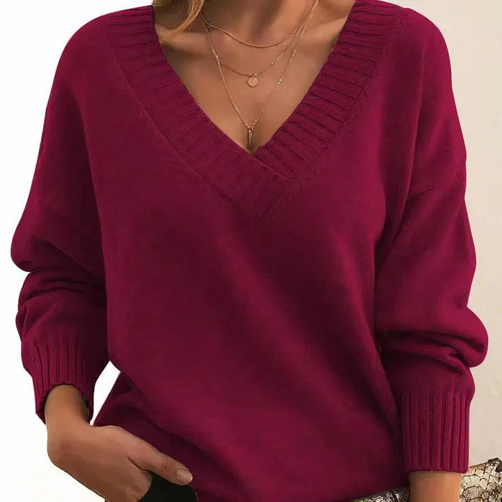 "Pull femme en cachemire col V, élégant et doux, fond beige, idéal pour élégance quotidienne et chaleur légère."