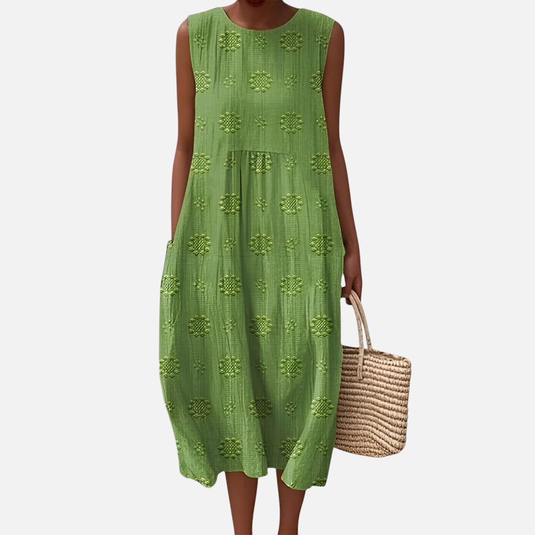 "Robe bohème élégante en coton, mi-longue sans manches, coupe fluide, avec poches, motif géométrique, style estival chic."