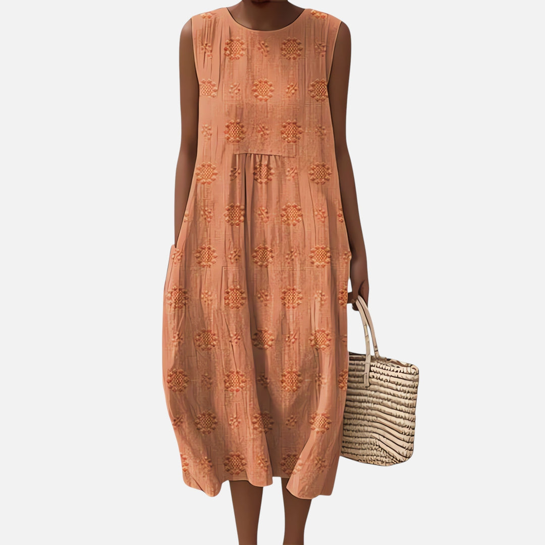 "Robe bohème élégante en coton, mi-longue sans manches, coupe fluide, avec poches, motif géométrique, style estival chic."