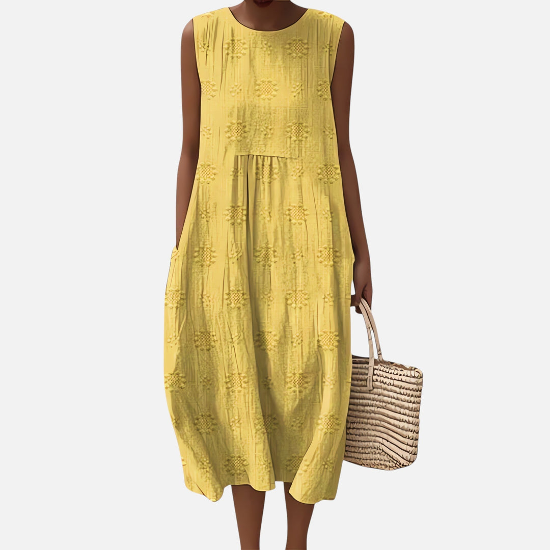 "Robe bohème élégante en coton, mi-longue sans manches, coupe fluide, avec poches, motif géométrique, style estival chic."