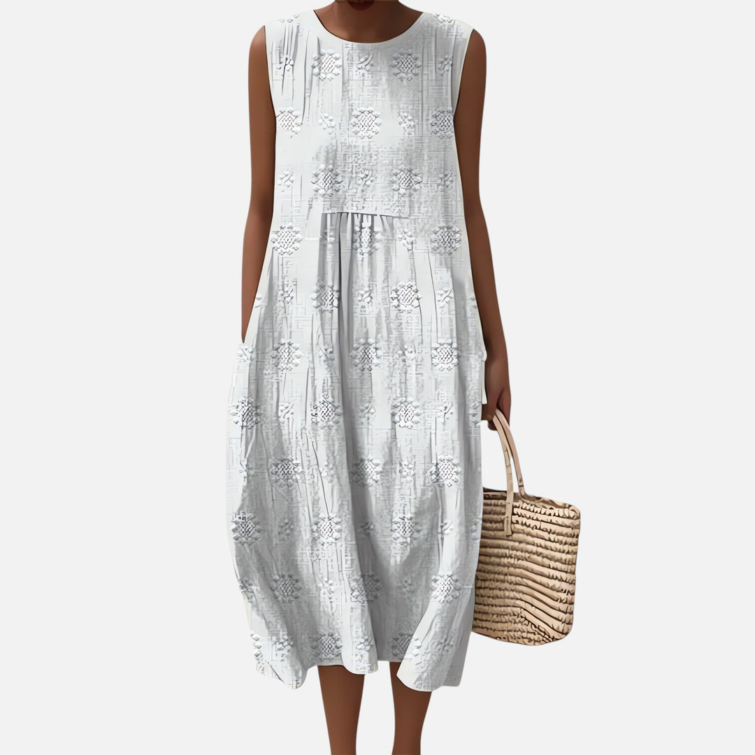 "Robe bohème élégante en coton, mi-longue sans manches, coupe fluide, avec poches, motif géométrique, style estival chic."