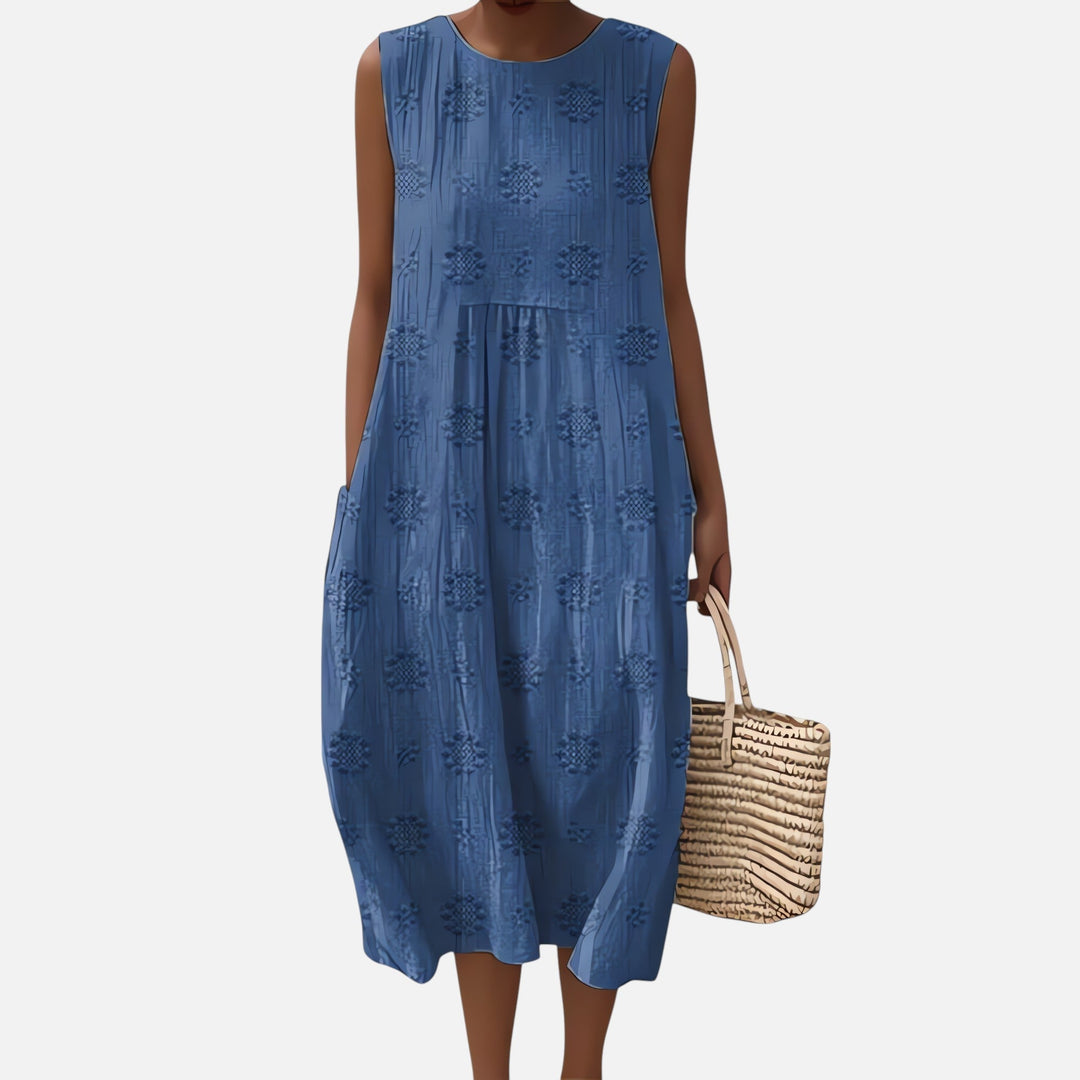 "Robe bohème élégante en coton, mi-longue sans manches, coupe fluide, avec poches, motif géométrique, style estival chic."