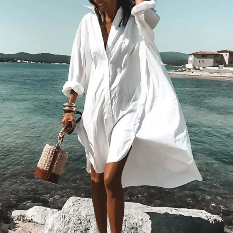 "Robe chemise blanche élégante d'été avec manches légères et détails aérés, silhouette féminine idéale pour sorties urbaines.