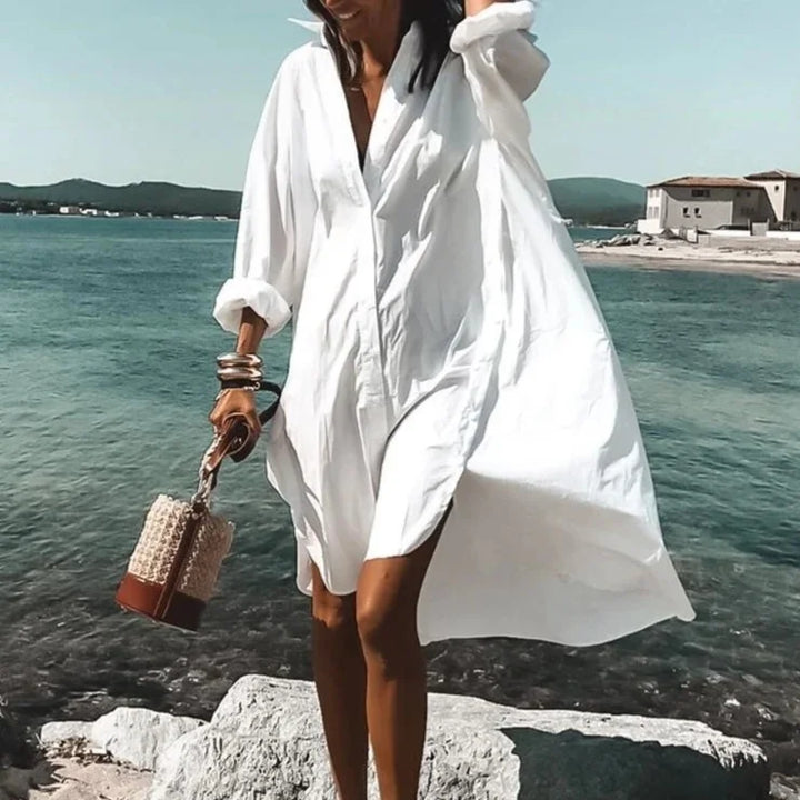 "Robe chemise blanche élégante d'été avec manches légères et détails aérés, silhouette féminine idéale pour sorties urbaines.