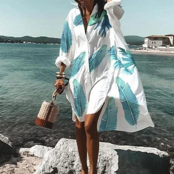 "Robe chemise blanche élégante d'été avec manches légères et détails aérés, silhouette féminine idéale pour sorties urbaines.