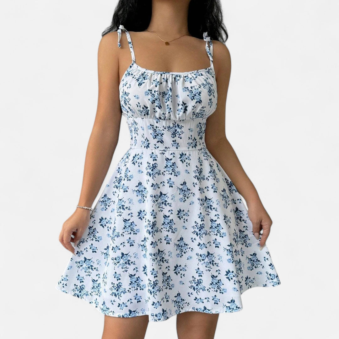 "Robe courte femme à bretelles fines avec imprimé fleuri, tissu léger pour l'été, coupe flatteuse et féminine."