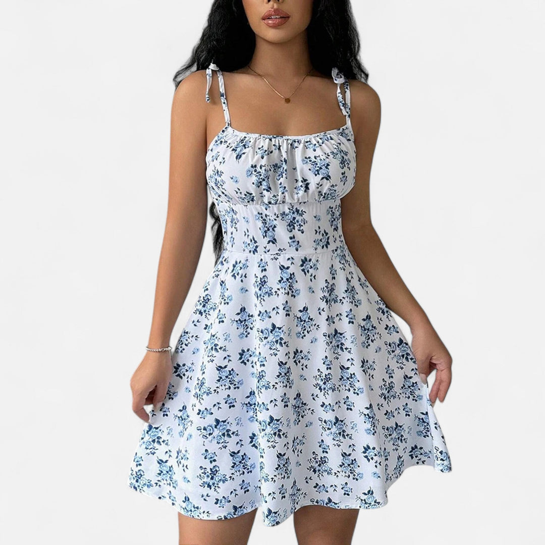"Robe courte femme à bretelles fines avec imprimé fleuri, tissu léger pour l'été, coupe flatteuse et féminine."