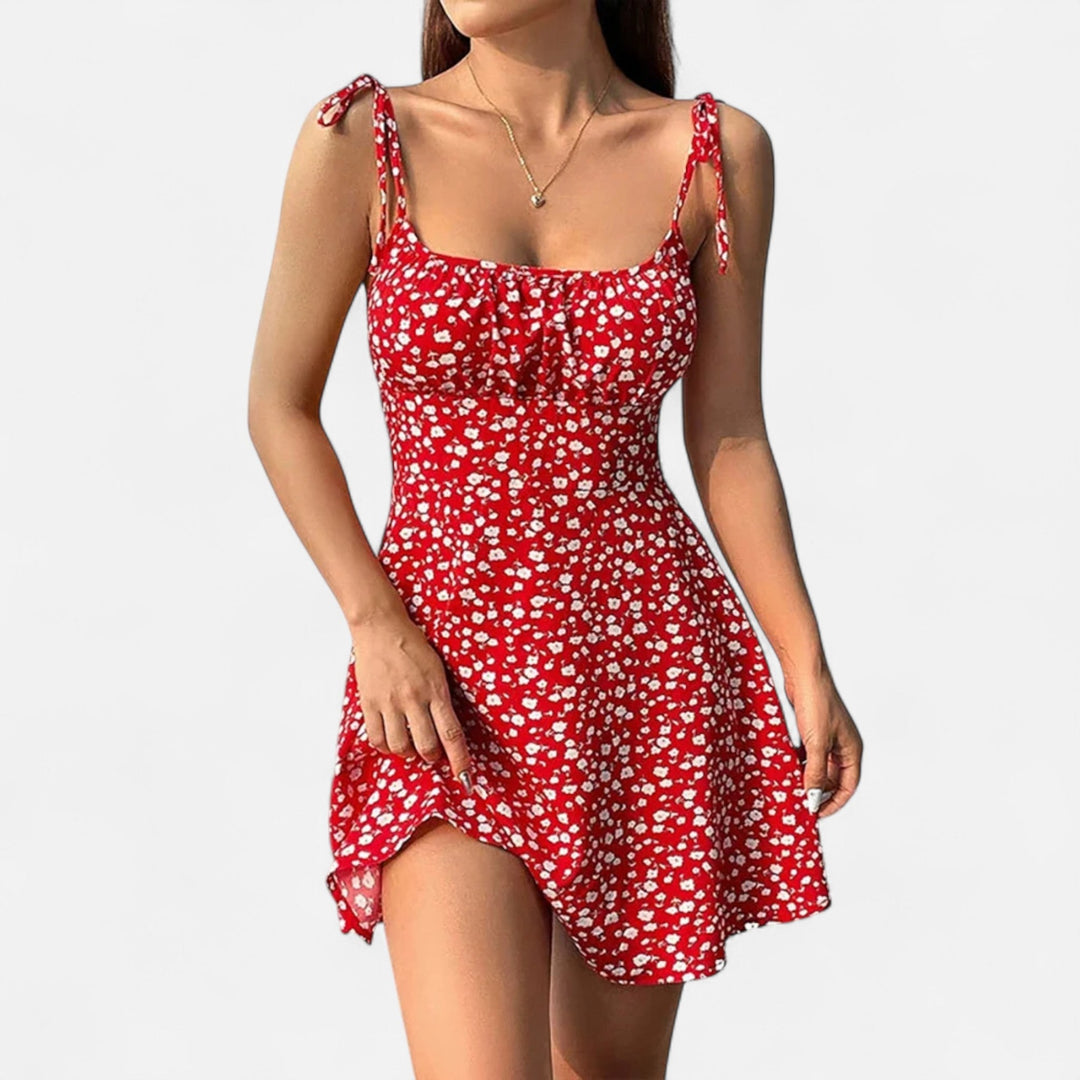 "Robe courte femme à bretelles fines avec imprimé fleuri, tissu léger pour l'été, coupe flatteuse et féminine."