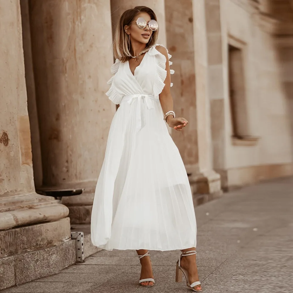Robe de mariée bohème fluide à volants élégants, coupe maxi, détails raffinés et chic pour mariages et occasions uniques.