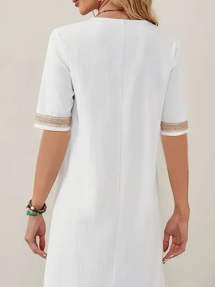 Robe d'été féminine avec col en V, détails en crochet, coupe fluide et élégante, idéale pour les journées ensoleillées.