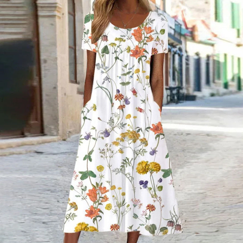 "Robe d'été fluide avec motifs floraux turquoise et blancs, coupe bohème chic, manches courtes, idéale pour l'été."