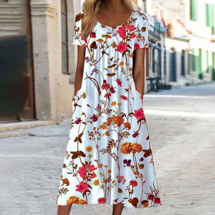 "Robe d'été fluide avec motifs floraux turquoise et blancs, coupe bohème chic, manches courtes, idéale pour l'été."