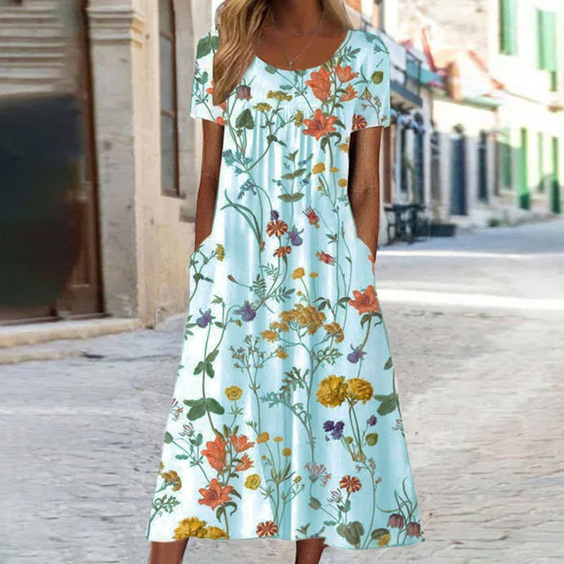 "Robe d'été fluide avec motifs floraux turquoise et blancs, coupe bohème chic, manches courtes, idéale pour l'été."