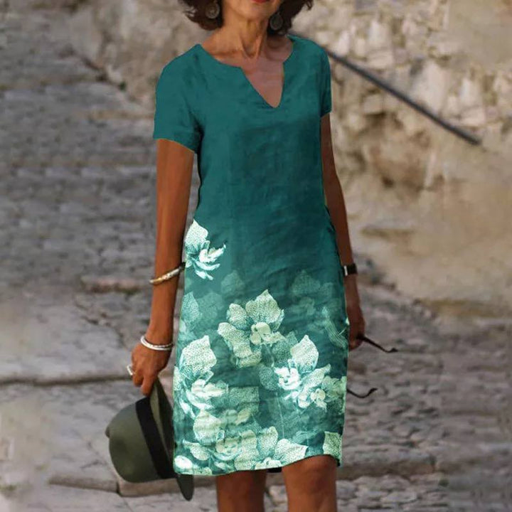 Robe d'été légère pour femme, imprimé floral coloré, tissu fluide, élégante pour journées chaudes et occasions décontractées.
