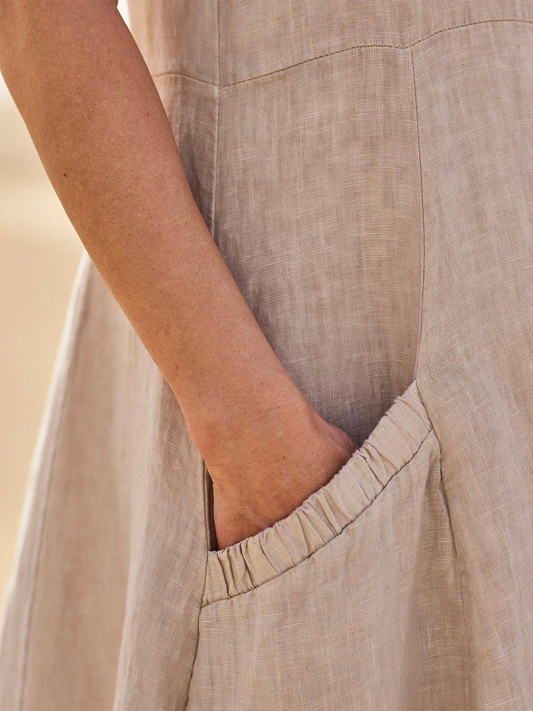 Robe élégante en coton beige, poches spacieuses, coupe fluide, idéale pour confort quotidien et élégance décontractée.