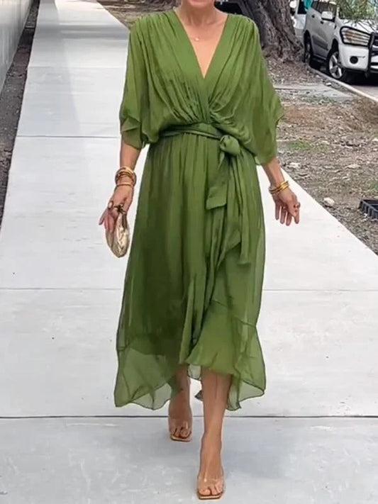 "Robe en mousseline de soie bleue avec col en V et manches 3/4, coupe fluide pour occasions élégantes."