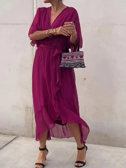 "Robe en mousseline de soie bleue avec col en V et manches 3/4, coupe fluide pour occasions élégantes."