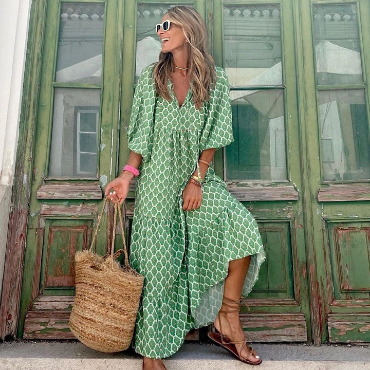 Robe longue bohème à imprimé vintage, col en V, manches amples sur fond estival pour un look décontracté et élégant.