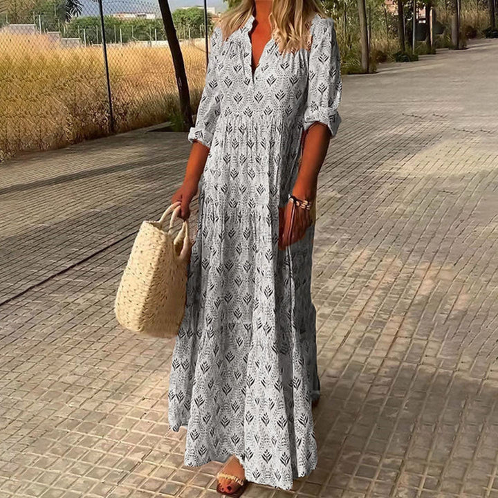 "Robe longue bohème bleu clair avec motif feuillage, coupe ample et élégante, idéale pour l'été."
