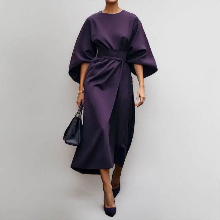 "Robe longue femme élégante avec manches chauve-souris, cintrée et drapé fluide, idéale pour occasions spéciales."