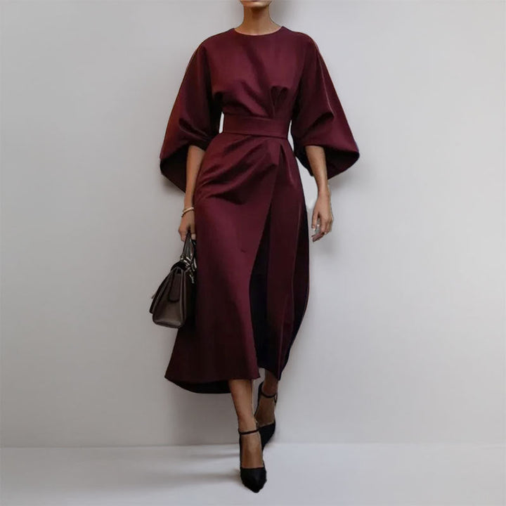 "Robe longue femme élégante avec manches chauve-souris, cintrée et drapé fluide, idéale pour occasions spéciales."