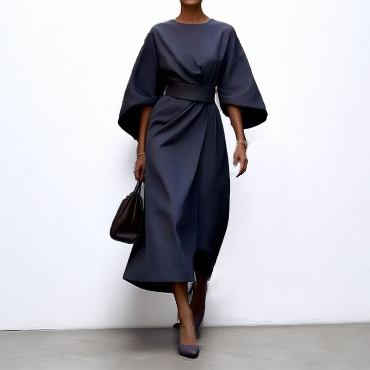 "Robe longue femme élégante avec manches chauve-souris, cintrée et drapé fluide, idéale pour occasions spéciales."
