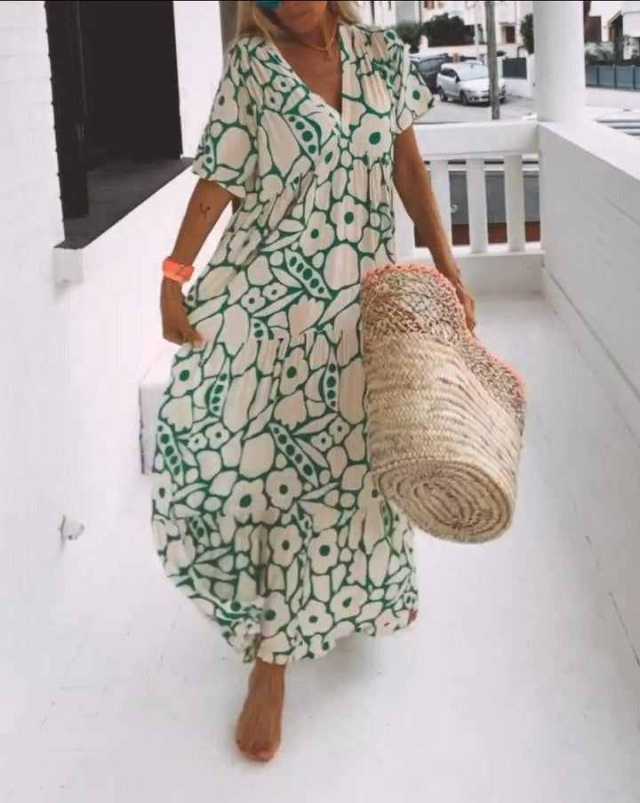 Robe longue fluide avec imprimé floral vert, manches courtes volantées et décolleté en V, idéale pour l'été.