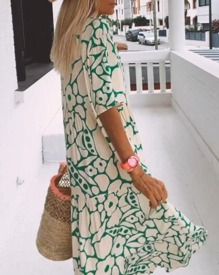 Robe longue fluide avec imprimé floral vert, manches courtes volantées et décolleté en V, idéale pour l'été.