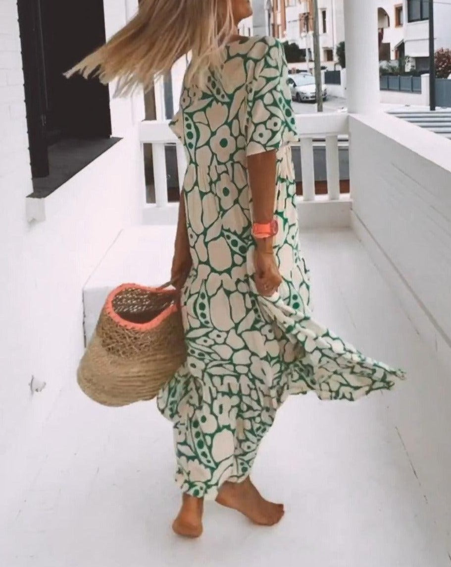 Robe longue fluide avec imprimé floral vert, manches courtes volantées et décolleté en V, idéale pour l'été.